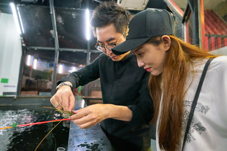 SINGAPORE - CIRCA APRIL, 2019: a man show caught prawn to a woman in Singapore.のeditorial素材