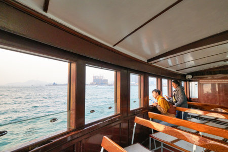 HONG KONG, CHINA - CIRCA JANUARY, 2019: people on a Star Ferry crossing Victoria Harbour. The Star Ferry is a passenger ferry service operator and tourist attraction in Hong Kong.のeditorial素材