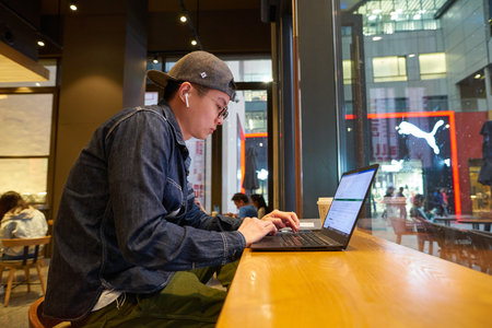 SHENZHEN, CHINA - CIRCA APRIL, 2019: man with laptop seen in Starbucks at UpperHills in Shenzhen.のeditorial素材