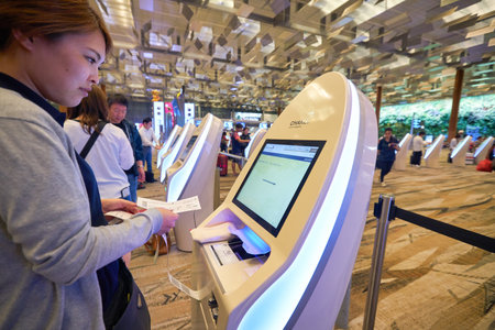 SINGAPORE - CIRCA JANUARY, 2020: a traveller at the self check-in kiosk at Terminal 3, Singapore Changi Airport. Changi Airport is a major civilian airport that serves Singapore.のeditorial素材