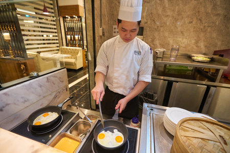 SINGAPORE - CIRCA JANUARY, 2020: man cooking fried eggs at Mercure Singapore Bugisのeditorial素材