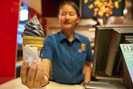 SHENZHEN, CHINA - CIRCA NOVEMBER, 2019: worker with ice cream cone at McDonald's Dessert Kiosk in Shenzhen.のeditorial素材