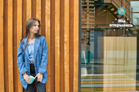 KALININGRAD, RUSSIA - CIRCA JULY, 2022: teenager with fast food restaurant Vkusno I Tochka, Russian fast food chain mostly based in former McDonald's restaurants, in the background.のeditorial素材