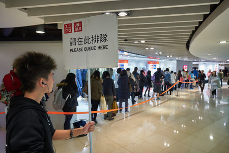 HONG KONG - CIRCA DECEMBER, 2019: people staying in queue at Uniqlo store in New Town Plaza shopping...