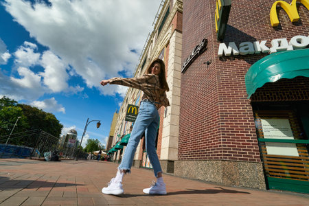 KALININGRAD, RUSSIA - CIRCA JULY, 2022: woman posing against the background of McDonald's restaurant, closed after sanctions were imposed.のeditorial素材