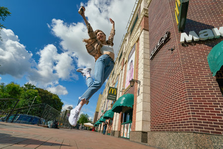 KALININGRAD, RUSSIA - CIRCA JULY, 2022: woman with paper cup against the background of McDonald's restaurant, closed after sanctions were imposed.のeditorial素材