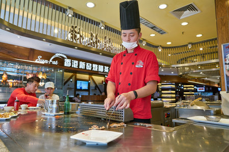 SHENZHEN, CHINA - CIRCA NOVEMBER, 2019: cook preparing food at restaurant in food republic at KK mall in Shenzhen.のeditorial素材