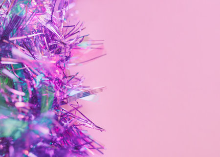 Tinsel Close up photo with copy space Shiny lilac tinsel on pink background Template for posters and bannersの写真素材