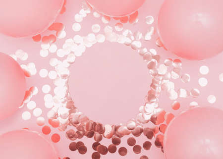 Party decoration. Flat lay photo with copy space. Shiny gold confetti and pink balloons on pastel backgroundの写真素材