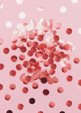 Top view photo with rose gold confetti. Glowing round sparkles on pastel pink backgroundの写真素材