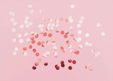 Rose gold confetti. Template for posters and banners. Top view photo. Shiny round confetti on pink backgroundの写真素材