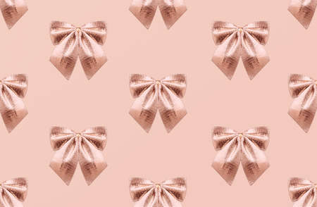 Monochrome seamless pattern with golden bow tie. Shining atlas bow knot on pastel backdropの写真素材