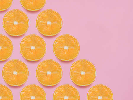 oranges. Top view photo in minimal style. Trendy concept with citrus fruits on pink backgroundの写真素材