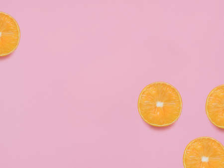 Citrus fruit. Top view photo with copy space. Slices of oranges on pink pastel backdropの写真素材