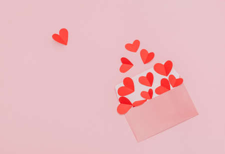 Valentine's Day mail. Flat lay photo with copy space. Many red paper hearts falling out of the...
