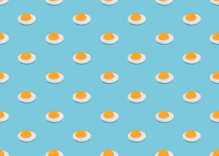Seamless pattern with fried eggs. Many very small omelets on blue backgroundの写真素材