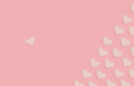 Top view photo with Valentine's day concept. White glazed candies in a heart shape on pink backdrop