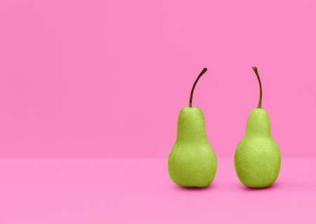 Pear. Photo with copy space in minimal style. Ripe green fruits standing on pink backgroundの写真素材