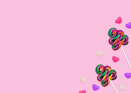 Lollipops. Design template with copy space. Colorful candies on sticks and bonbons on pink backdrop