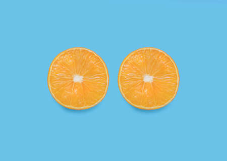 tropical fruit. Top view photo close up. Halved ripe orange on light blue backdropの写真素材