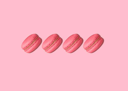 macaroons. Layout in minimal style. Pink almond biscuits on pastel pink background