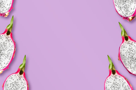 Flat lay photo with delicious dragon fruits. Template for posters, banners with copy space. Bright cutted pitahaya on purple backgroundの写真素材