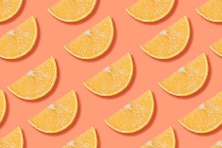 Colorful seamless pattern of fresh orange slices on bright background. Top view photo with cutted...