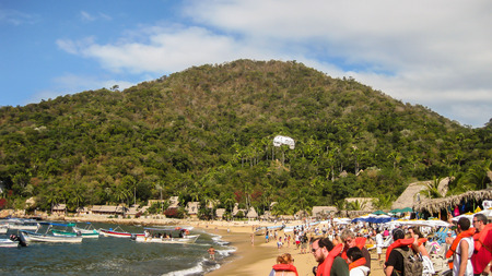 Yelapa, Mexico- December 30, 2010: Tourists await loading a boat and others just relax on the beach at this quiet but busy fishing village in Mexico.のeditorial素材