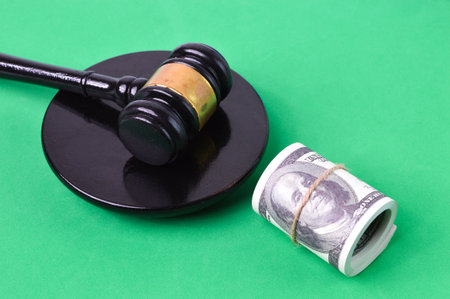 Judge gavel and money banknotes over green background. Selective focus