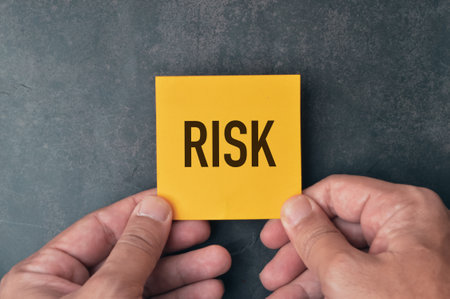 Top view of hand holding a memo note written with text RISK.の写真素材