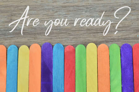 Top view of colorful ice cream sticks over wooden background written with question ARE YOU READY?