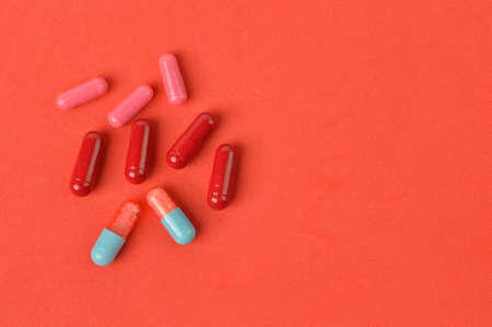 Top view of pill capsules over red background
