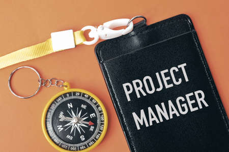 Top view of magnetic compass and name tag written with text PROJECT MANAGER.の写真素材