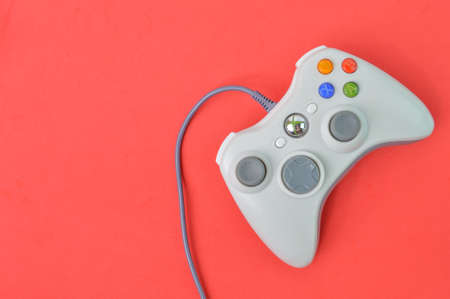Top view of joystick game controller over red background.