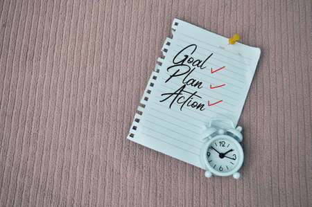 Top view of white paper and clock written with text GOAL, PLAN ACTIONの写真素材