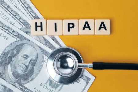 Money banknotes, stethoscope and letters with text HIPAA stands for Health Insurance Portability And...