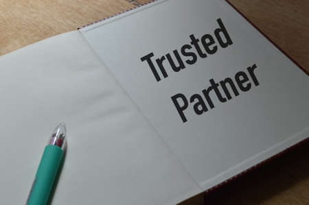 Pen and notebook written with text TRUSTED PARTNER. Business concept.の写真素材