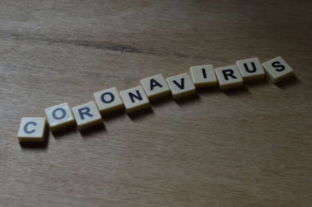 Square letters with text CORONAVIRUS over wooden background.の写真素材