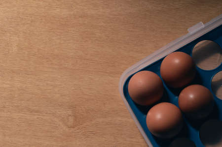 Chicken eggs in box over wooden background. Selective focus.
