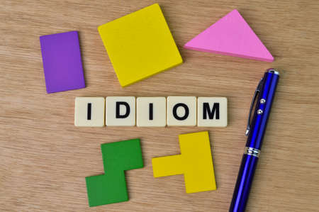 Pen, colorful wooden blocks and square letters with text IDIOM.の写真素材
