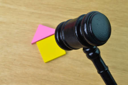 Judge gavel and toy house over wooden background. Selective focus.の写真素材