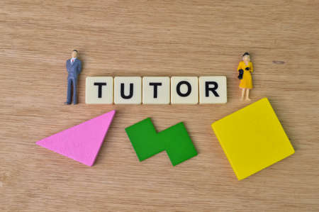 Wooden blocks, people miniatures and square letters with text TUTOR.