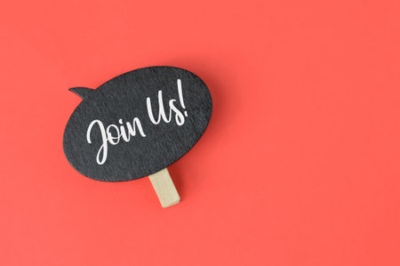 Wooden tag written with JOIN US over red background.の写真素材