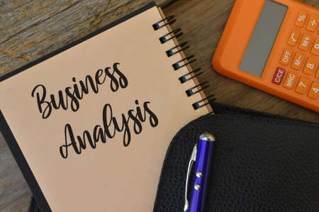 Pen, black file, calculator and notebook written with BUSINESS ANALYSIS.の写真素材