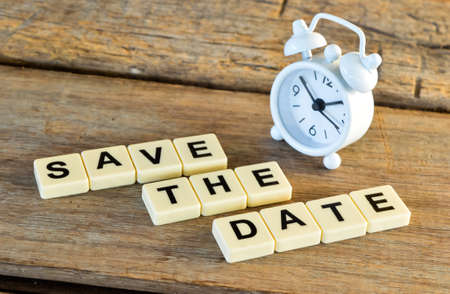 Clock and square letters with text SAVE THE DATE on the table.の写真素材