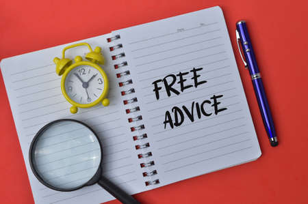 Notebook written with text FREE ADVICE isolated on a red background.の写真素材