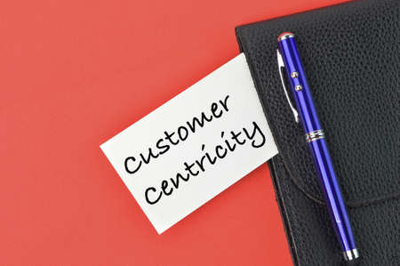 Pen, black file and memo note written with text CUSTOMER CENTRICITY.