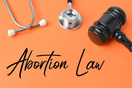 Judge gavel, stethoscope over orange background written with ABORTION LAW.の写真素材