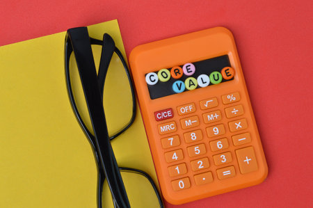 Eyeglasses, calculator and alphabet beads with text CORE VALUE.の写真素材