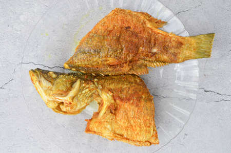 Top view of fried Barramundi Fish on a glass plateの写真素材